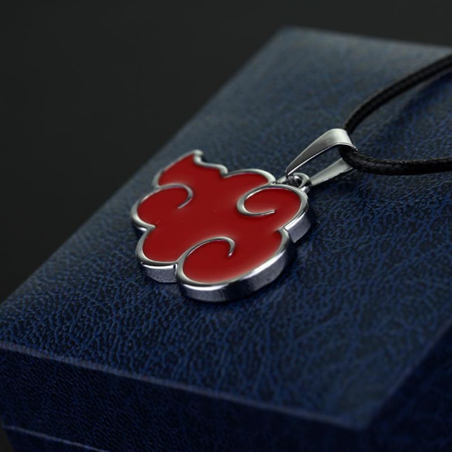 Red and silver pendant on a black cord against a dark blue textured background