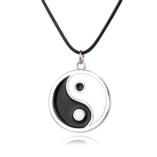 Yin and yang symbol pendant on a black cord against a white background