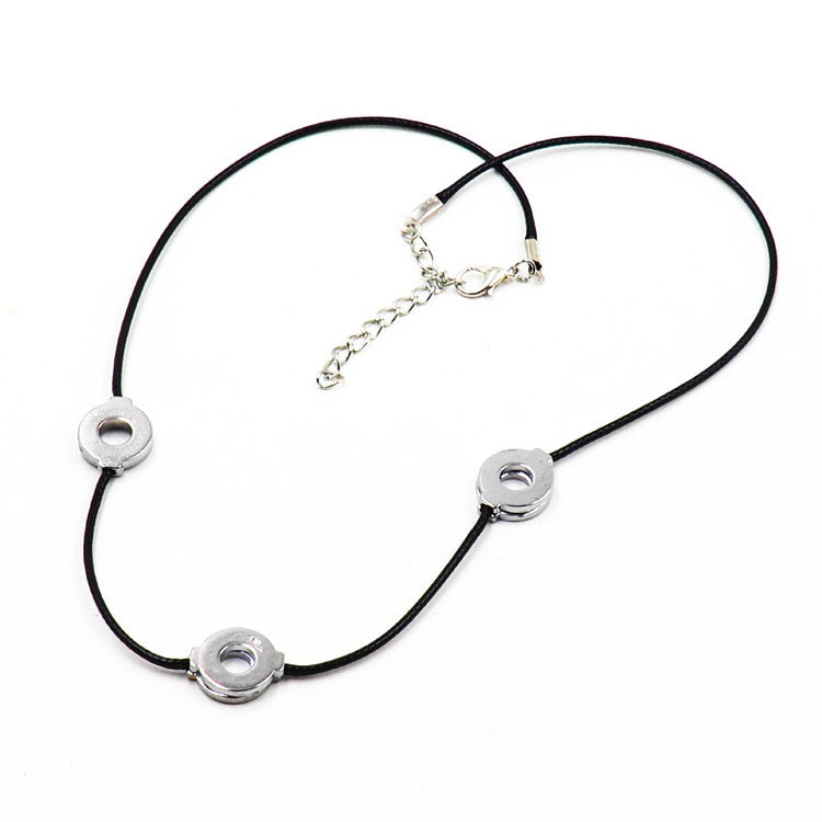 Necklace with black cord and silver circular pendants on a white background