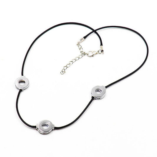Necklace with black cord and silver circular pendants on a white background