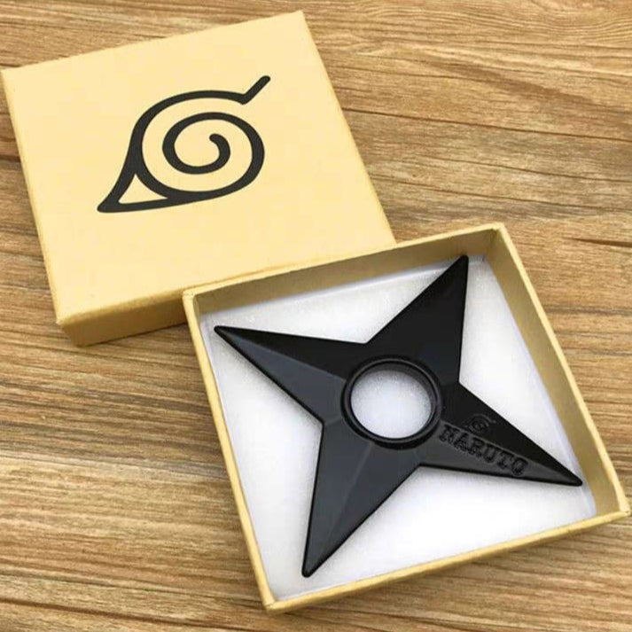 Black fidget spinner with a symbol in a wooden box on a wooden surface