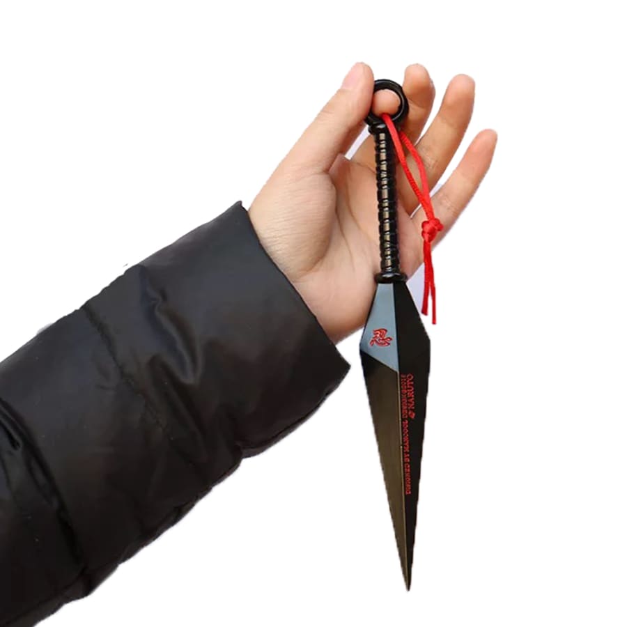 Hand holding a black knife with a red string on a white background