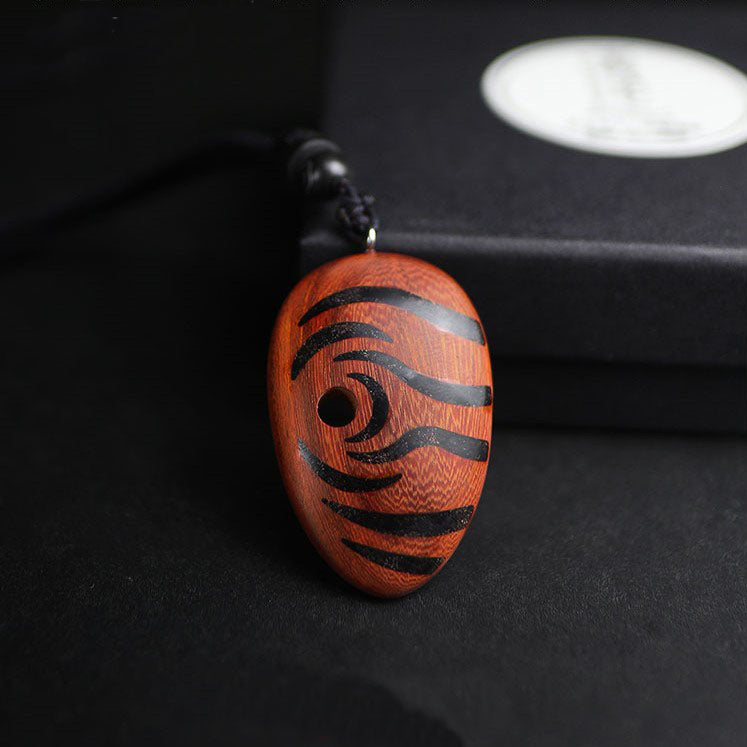 Wooden pendant with black patterns on a dark background